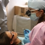 Students Andrea Hetherington in scrubs and Krystal Hayes acting as the "patient" practice their skills.  