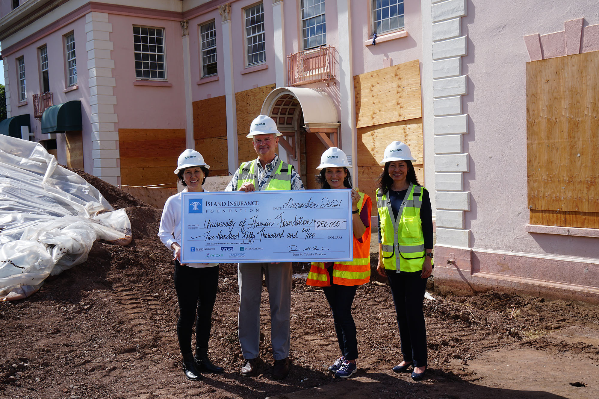 Susan Yamada, Vance Roley, Dana Tokioka and Kristi Bates hold a large check in front of the RISE project at the University of Hawaii